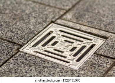 Water drain vent in kitchen  bathroom basement ceramic tiled old vintage floor  Geometric abstract beige background 