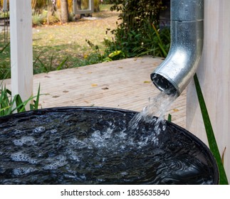 Water drains from the drain pipe into a metal container - Shutterstock ID 1835635840