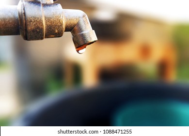 Water Dripping Out From The Faucet Down To Support Bucket