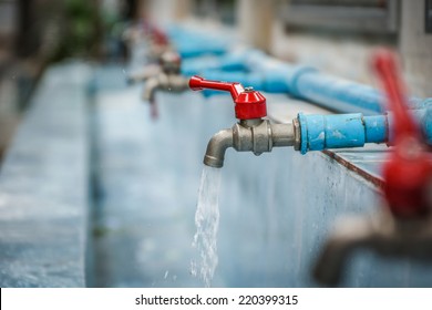 Water Drop From Chrome Faucet And Water Pipeline Background. Wash Basin Ceramic Tile At Bathroom. Drink Water Plumbing Pipeline. Resource Conserve Concept.