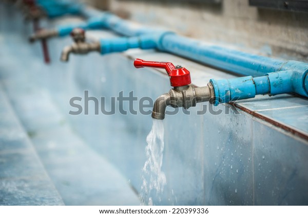 Water drop from chrome faucet and water\
pipeline background. Wash Basin ceramic tile at bathroom. Drink\
water plumbing pipeline. Resource conserve\
concept.