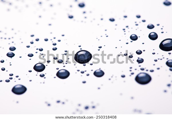 Water drop and droplet on mirror bright white\
and blue background