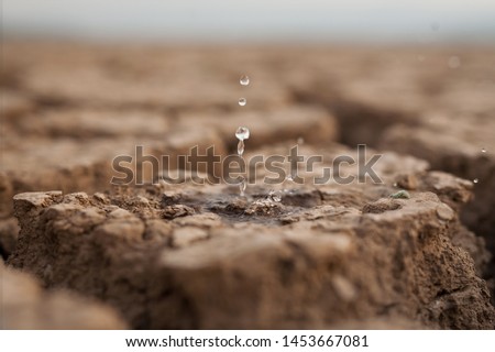 Water drop to dry cracked land metaphor lack of rain, water crisis, Climate change and Environmental disaster
