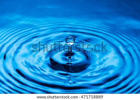 Water drop falling down. Abstract blue background. 