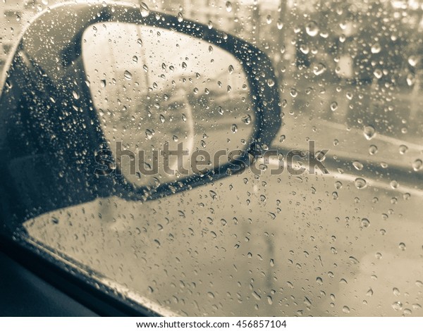 The water\
drop on glass of car with mirror of\
car.