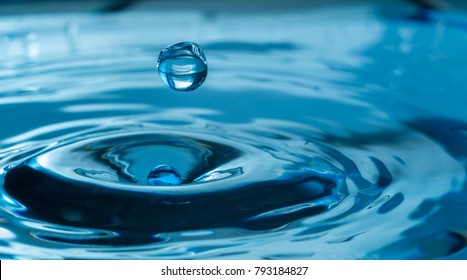 water drop splash in a glass blue colored - Shutterstock ID 793184827