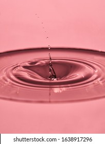 water drop splash in a glass rose colored.