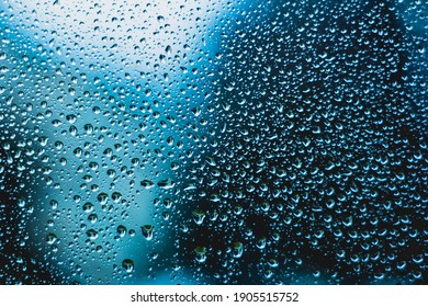 Water Droplets Background Texture On Window Macro Front View Blue Tint Backlit.