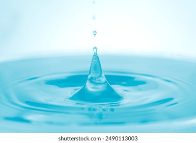 Water droplets falling on water surface created ripples with blue sky  light effect background. - Powered by Shutterstock