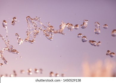 Water droplets frozen in the air with splashes and chain bubbles on a golden and bronze isolated background in nature. Clear and transparent liquid symbolizing health and nature. - Powered by Shutterstock