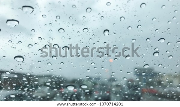 Water droplets on\
Car mirror with traffic jam background. raindrop at glass on car.\
traffic jam and raindrop