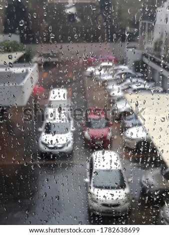 Rainy day I View through a wet window pane onto a busy street