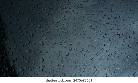 Water droplets on glass, with a dark background because it is cloudy. - Powered by Shutterstock