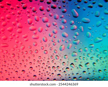 Water droplets on a glass surface with a vibrant multicolored gradient background, creating a visually appealing abstract texture. abstract close-up of water droplets against a colorful background - Powered by Shutterstock