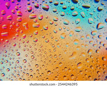 Water droplets on a glass surface with a vibrant multicolored gradient background, creating a visually appealing abstract texture. abstract close-up of water droplets against a colorful background - Powered by Shutterstock