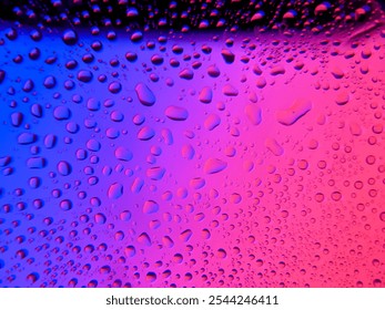 Water droplets on a glass surface with a vibrant multicolored gradient background, creating a visually appealing abstract texture. abstract close-up of water droplets against a colorful background - Powered by Shutterstock