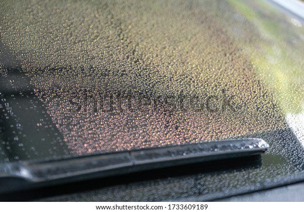 Water droplets on the windscreen after\
washing the car. Water droplets on the glass. Abstract and Blur\
water droplets\
background.