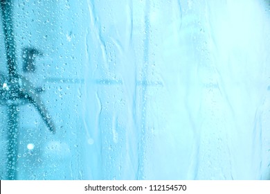 Water dropping down the glass of a shower.