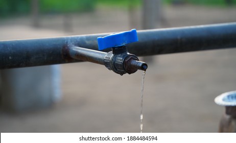 Water dropping view from blue water Valve with blurred background. Closeup view of Water leak from iron pipe. Save water concept.
