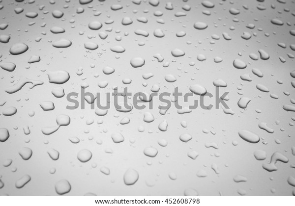 Water\
drops collect on top of metallic car surface as abstract background\
 - Rain drops - soft light tone - Black and\
White