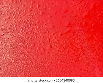 Water drops of different sizes on a red surface. Close-up showing a mix of small and large condensation or rain droplets. - Powered by Shutterstock - Get 15% off with code: PIKWIZARD15