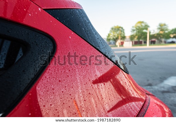 Water drops\
on the back of a newly washed red\
car.