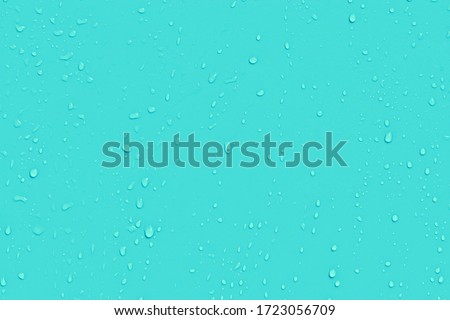 Water drops on blue background. Liquid droplets on bright color plastic surface. Raindrops texture. Abstract wet dewy background