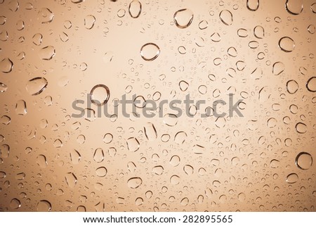 water drops on brown glass background.