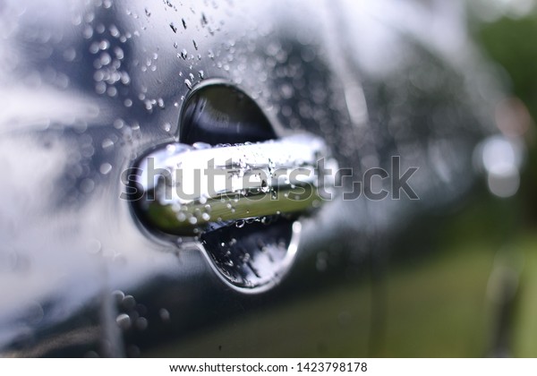 water drops on car black surface blurred background\
selective focus