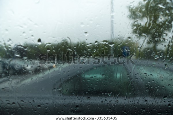 water drops on car glass through which are visible
other cars