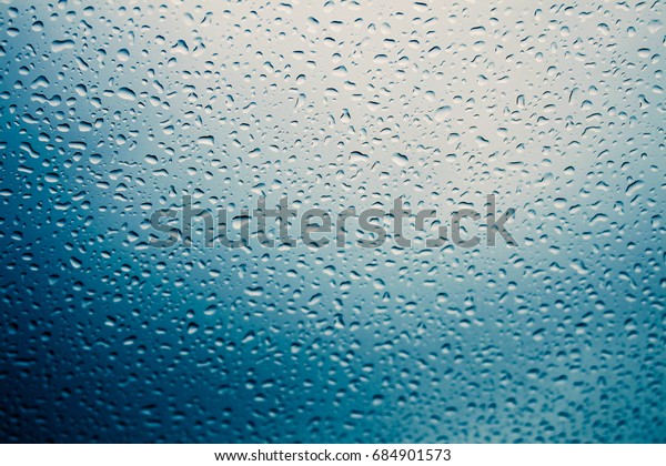 Water drops on car\
glass while it rains.