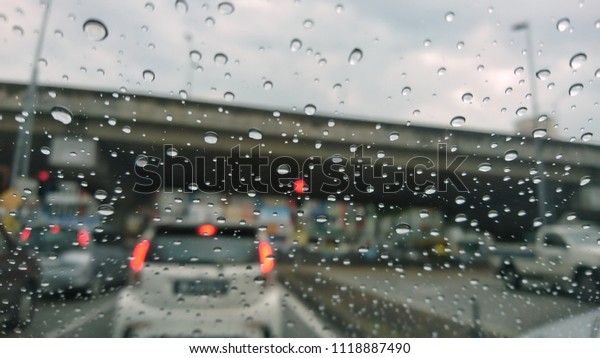 Water drops on a car mirror. View\
through a car window and selective focus on the raindrop.\

