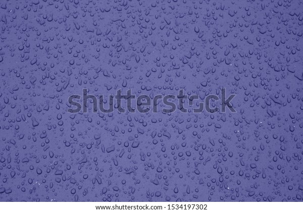 Water drops on car surface in blue tone.\
Abstract background and texture for\
design.