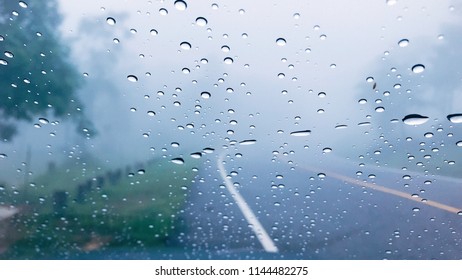 Water Drops On Car Window After The Rain With Blur Line Street Road And Fog Background In The Forest