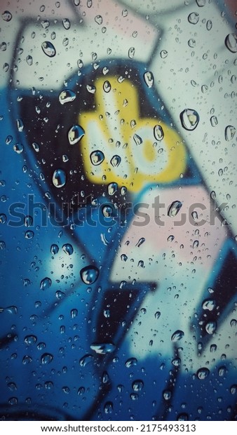 water drops on car\
window with graffiti view