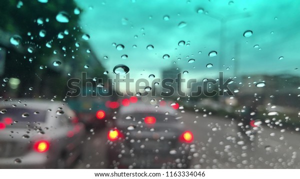 Water Drops
on the car windshield, traffic in the city on a rainy day at
evening, colorful bokeh, blurry
background.