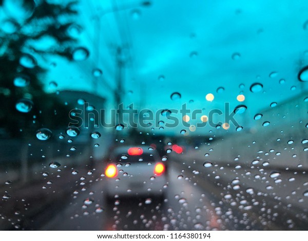 Water Drops\
on the car windshield, traffic in the city on a rainy day at\
evening, colorful bokeh, blurry\
background.
