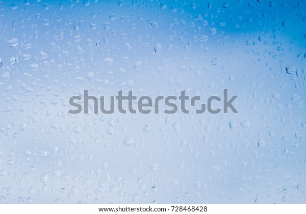 Water drops on clear glass after a heavy\
rainstorm in the rainy season.\
Bokeh blur of water droplets on sky\
background