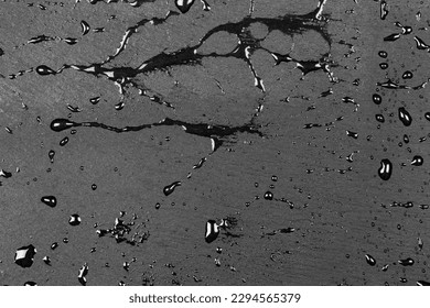 Water drops on dark flat stone surface of basalt or granite background texture - Shutterstock ID 2294565379