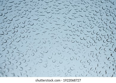 Water drops on glass. Raindrops on the windshield of the car. Melted snowflakes on the glass. Beautiful pattern of raindrops on glass.