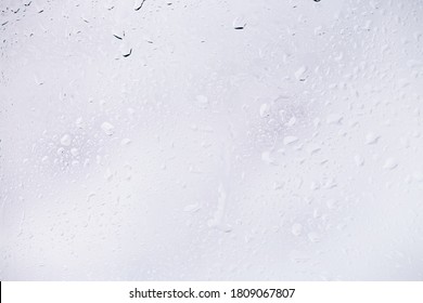 Water Drops On Glass On A White Background. Water Drop Texture As Background. Freshness After The Rain. Ecology Of Wet Clean Nature. Steam In The Shower