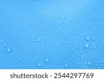 Water drops on light blue background, top view