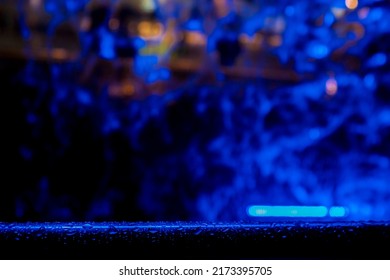 Water Drops On A Metal Bar In Focus. Falling Blue Water Out Of Focus In The Background. Night Club Decoration Theme