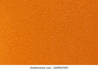 Water Drops On Orange Background. Full Frame Photo.