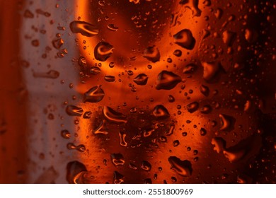 Water drops on red glass surface, macro view