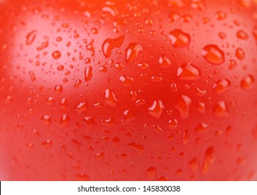 Water Drops On Red Tomato. Close Up.