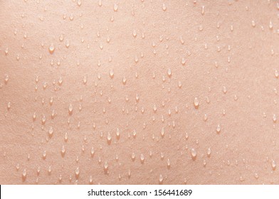 Water drops on the skin of a young woman in the sun