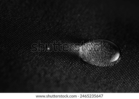 Water drops on waterproof black fabric.