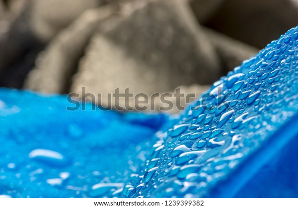 Water\
drops on waterproof blue nylon fabric. Macro detail view of woven\
synthetic waterproof clothing. Waterproof fabric with waterdrops.\
Rain Drops on Water Resistant Textile\
Coating.