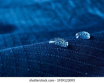 Water drops on waterproof membrane fabric. Detail view of texture of blue waterproof cloth.